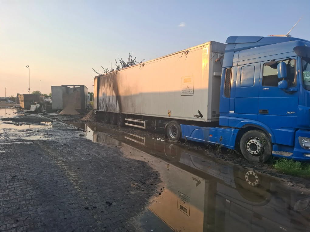Pojazd ciężarowy i teren składowiska po pożarze